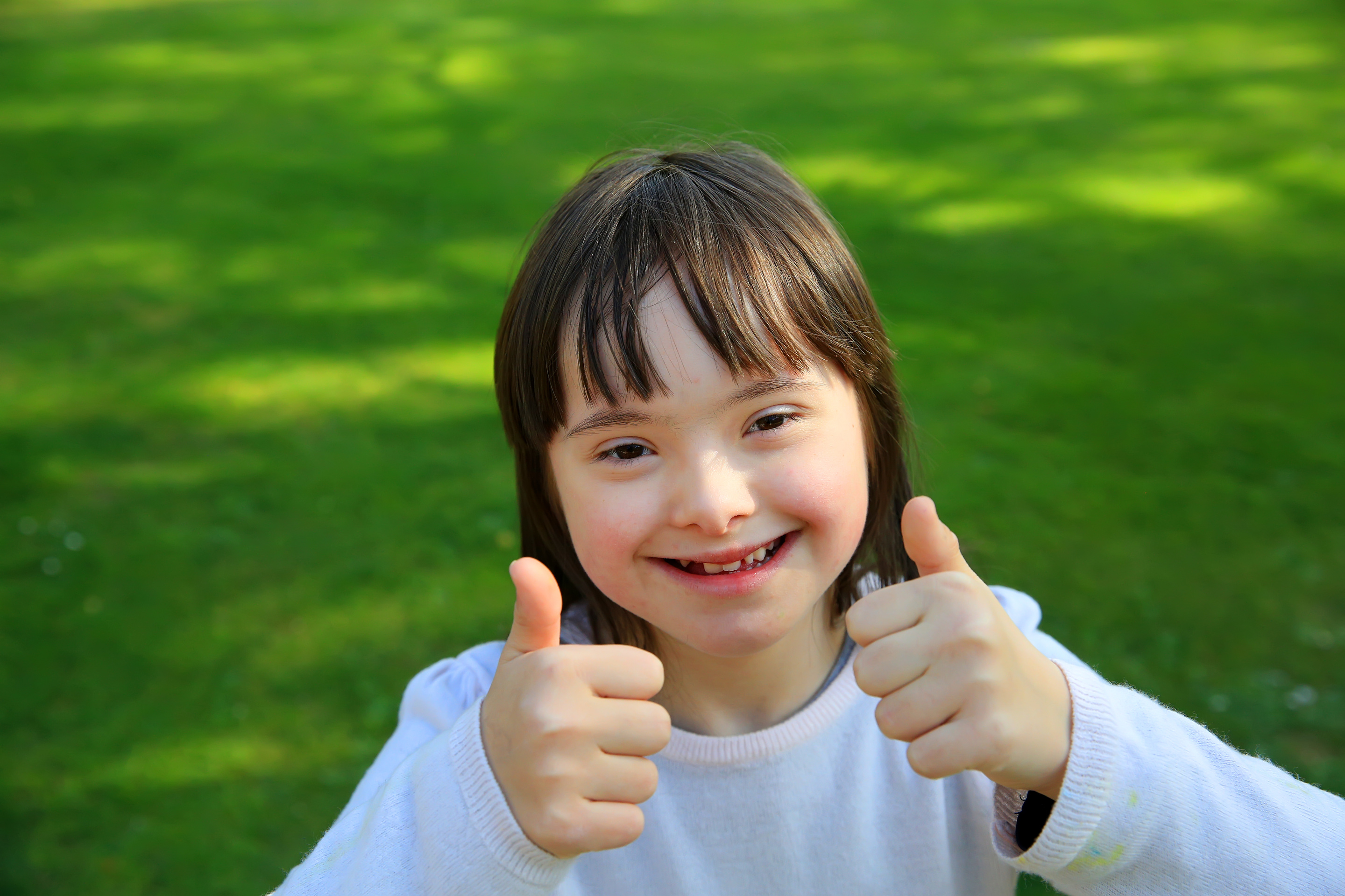 Portrait of a Girl with Down Syndrome Smiling in the Park